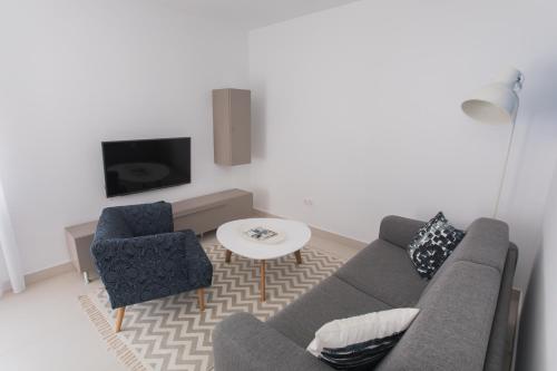 a living room with a couch and a table and a tv at blue adria in Primošten