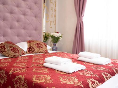 a bedroom with a red bed with towels on it at The Zanadu İstanbul in Istanbul