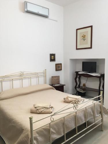 ein Schlafzimmer mit einem Bett und einem Schreibtisch mit einem Klavier in der Unterkunft B&B Domus Gaetani in Syrakus
