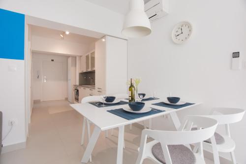 a white dining room with a white table and chairs at blue adria in Primošten