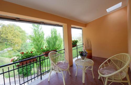 a balcony with two chairs and a table and a window at Monteleto House.. dove Pace regna in Gubbio