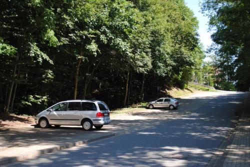 two cars parked on the side of a road at Panorama Hotel Pension Frohnau in Bad Sachsa