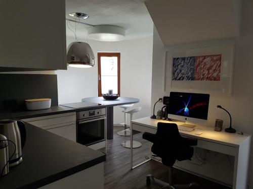 a kitchen with a desk with a computer on it at Little Castle near Airport and Messe in Steinenbronn