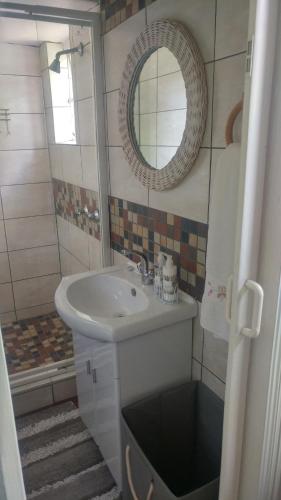 a bathroom with a sink and a mirror at Love Joy Peace Cottage in Pretoria