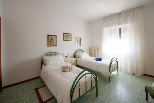 1 dormitorio con 2 camas y ventana en Monteleto House.. dove Pace regna, en Gubbio