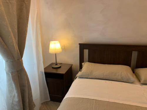 ein Schlafzimmer mit einem Bett und einer Lampe auf einem Tisch in der Unterkunft Domus Monasteire in Pagani