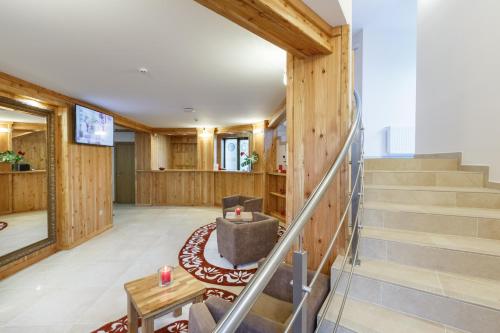 a living room with stairs and a chair at Baron SPA Hotel - Museum Yaremche in Yaremche