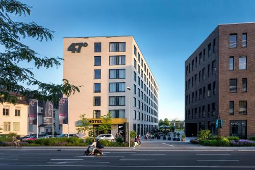 a building on a city street with people on scooters at Hotel 47° in Konstanz