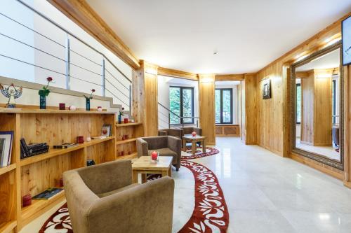 ヤレムチャにあるBaron SPA Hotel - Museum Yaremcheの木製の壁、椅子とテーブルが備わる広い客室です。
