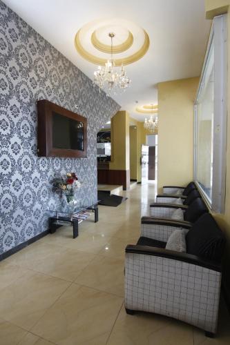eine Lobby mit Sofas und einem TV an der Wand in der Unterkunft Hotel Versailles Internacional in Guayaquil