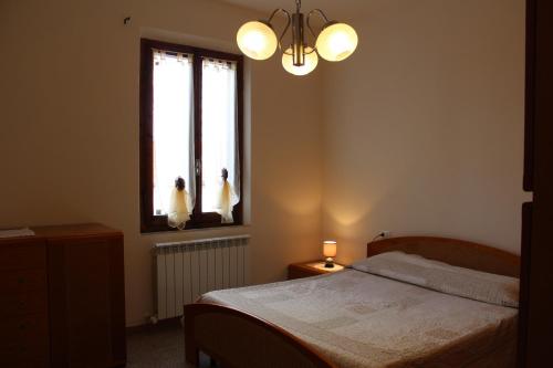 een slaapkamer met een bed en twee personen in een raam bij Via Roma 44 in Follonica