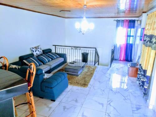 a living room with a blue couch and a table at Villa contemporaine in Yaoundé