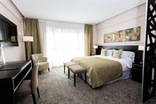 a hotel room with a large bed and a desk at Konke Buenos Aires Hotel in Buenos Aires
