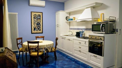 uma cozinha com uma mesa e um micro-ondas em Sirentum Suite em Sorrento