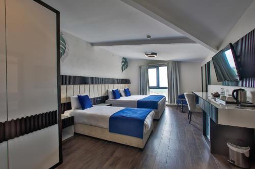 a hotel room with two beds and a sink at Kavala Hotel in Bursa