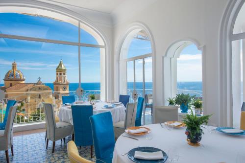 a restaurant with tables and chairs and a view of the ocean at Tramonto d'Oro in Praiano