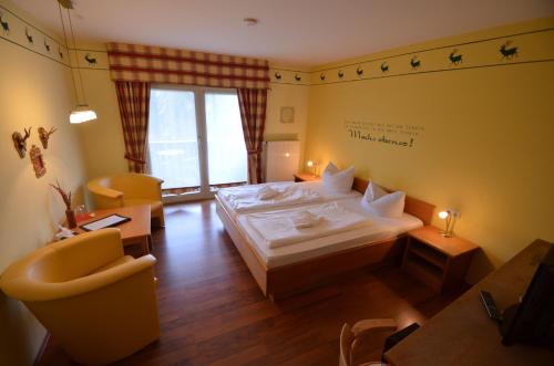 GrafenwiesenにあるLandhotel Christopherhofのベッド、テーブル、椅子が備わるホテルルームです。