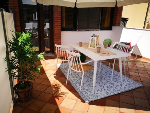 a white table and chairs on a patio at Amelia Apts & Rooms in Alghero