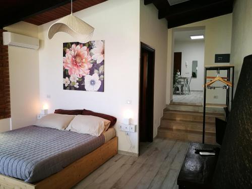 a bedroom with a bed with a painting on the wall at Amelia Apts & Rooms in Alghero