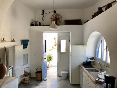 cocina con fregadero y nevera blanca en Spacious Paros, Lefkes house with awesome view, en Kampos