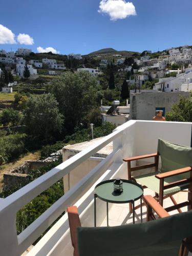 Un balcón con sillas y una mesa en un tejado. en Spacious Paros, Lefkes house with awesome view, en Kampos