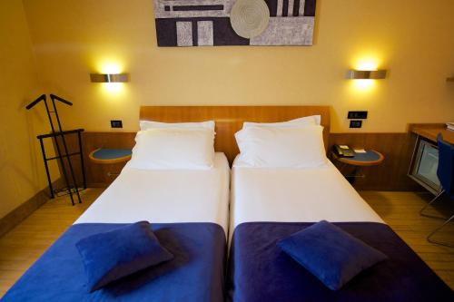 two beds in a hotel room with two pillows at Best Western Hotel Luxor in Turin