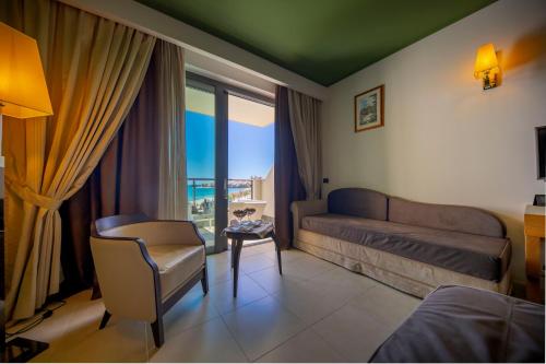 a living room with a couch and a chair and a window at Cefalù Sea Palace in Cefalù