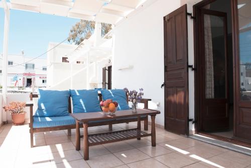 a patio with a blue couch and a table at Calderimi Apartments in Fira