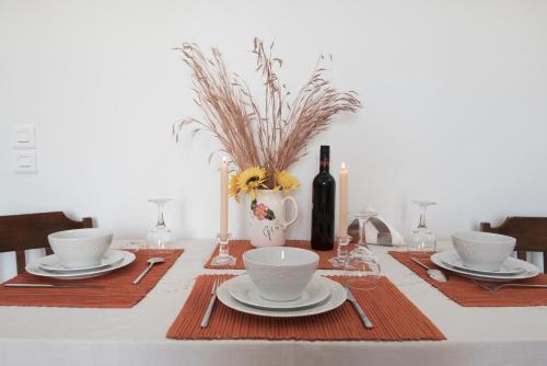 a table with plates and cups and a bottle of wine at Calderimi Apartments in Fira