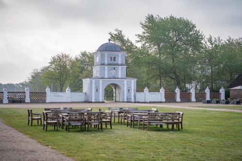 a group of tables and chairs in front of a clock tower at Nørre Vosborg Hotel & Gastronomi in Vemb