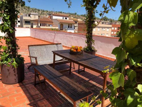 - une table avec un bol de fruits et un banc sur une terrasse dans l'établissement Casa Rural "Casa Maria", à Artana