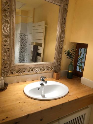 une salle de bain avec un lavabo blanc et un miroir dans l'établissement Appartement piscine, à Tonneins