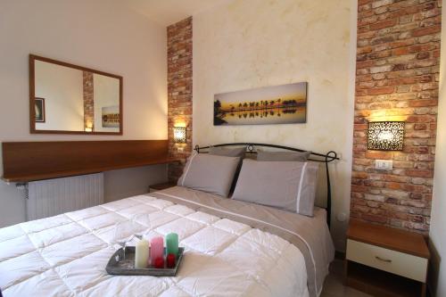 Un dormitorio con una cama con una bandeja de velas. en Appartamento Onda Blu, en Peschiera del Garda