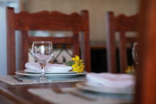 a table with a wine glass and a yellow flower on it at Aetovigla Guesthouse in Krousón