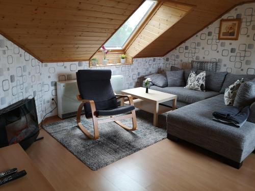 ein Wohnzimmer mit einem Stuhl und einem Sofa in der Unterkunft Ferienwohnung Schmitz in Welling