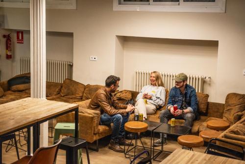 three people sitting on a couch in a living room at Safestay Barcelona Gothic in Barcelona