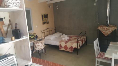 a bedroom with a bed and a table and a desk at Ierapetra Garden House in Ierapetra