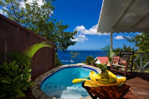 una piscina con un montón de plátanos y piña en una mesa en Ti Kaye Resort & Spa, en Anse La Raye