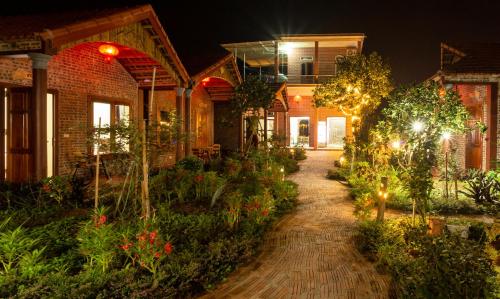 a brick house with a garden at night at Ruby Homestay in Ninh Binh