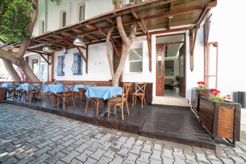 ein Restaurant mit Tischen und Stühlen auf einer Terrasse in der Unterkunft 9Bodrum Hotel in Turgutreis