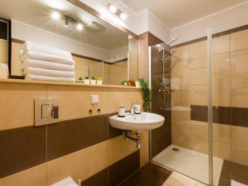 een badkamer met een wastafel en een douche bij VacationClub - Olympic Park Apartament B404 in Kołobrzeg