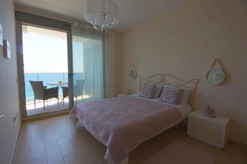 - une chambre avec un lit et un balcon avec une table dans l'établissement Beautiful frontline apartment MELIORIA with panoramic seaview, à Calp