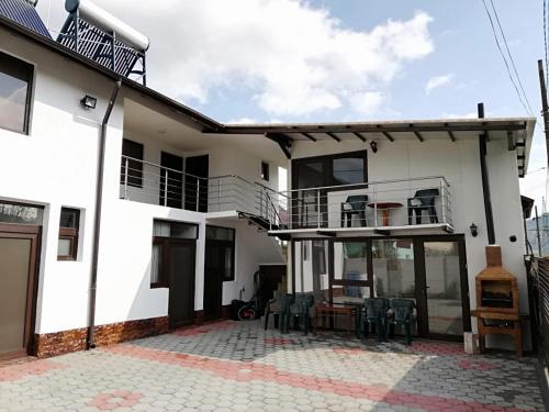 a white house with a patio and a balcony at Laubert in Călimăneşti