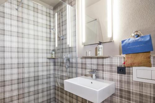 ein Bad mit einem Waschbecken und einem Spiegel in der Unterkunft Hotel Rad in Tettnang