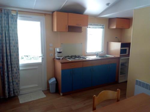 une cuisine avec un évier et une cuisinière four supérieur dans l'établissement Camping Le Vialaret, à Nant