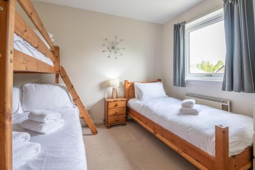 a bedroom with two bunk beds and a window at White Corries in Aviemore