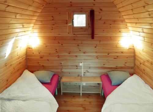 um quarto com duas camas num chalé de madeira em La Rossignolerie - POD Cabanes des châteaux em Chouzy-sur-Cisse
