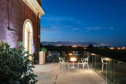 a patio with chairs and a table at night at Zash Country Boutique hotel & SPA in Giarre
