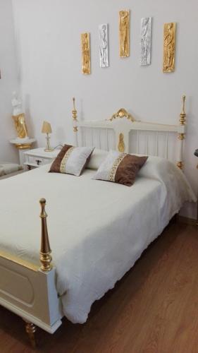 a white bed with two pillows on top of it at Império Romano Guest House in Beja