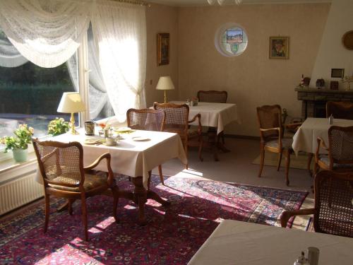 ein Esszimmer mit Tischen, Stühlen und einem Fenster in der Unterkunft Hotel Ohrberg in Hameln